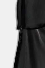 Vestido midi negro confeccionado en hilatura de viscosa, de diseño satinado y corte asimétrico con escote fluido y manga sisa. Presenta bajo acabado en línea evasé y cierre lateral con cremallera oculta en costura.