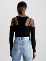 Remera Calvin Klein negra de punto canalé con doble capa y efecto 2 en 1. Tiene mangas largas con hombros descubiertos y logo bordado en el lateral. Corte slim cropped.