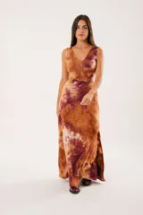 Vestido largo con estampado batik en tonos marrones y borgoña, escote en V, sin mangas y abertura lateral.