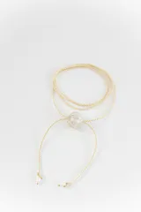 Gargantilla tipo bolo tie de tiento trenzado verde con dije esférico celeste con brillos incrustados.