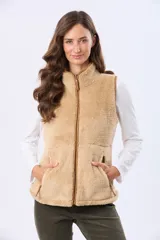 Chaleco de tejido sherpa color beige, con cuello alto y detalles en eco cuero. Diseño sin mangas que proporciona abrigo al torso manteniendo la libertad de movimiento.