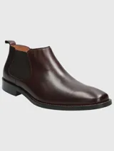 Bota Chelsea de cuero color vino (bordó oscuro) con puntera cuadrada y elástico lateral negro. Posee suela negra con costura de vira visible en color marrón claro.