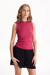 Musculosa de rib de algodón color blanco, con calce ajustado, escote redondo alto y sin mangas.