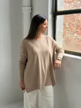 Sweater de punto color visón con cuello redondo, mangas largas con puños acanalados y diseño holgado con detalle de costura vertical central.