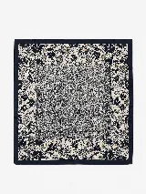 Pañuelo cuadrado de seda con diseño estampado que combina un centro texturizado en tonos grises y negros con un borde decorado con motivos florales en azul marino, crema y toques dorados.