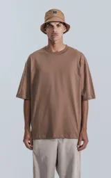 Remera de corte holgado y diseño relajado, con cuello redondo y mangas cortas con hombros caídos. Presenta un largo a la altura de la cadera.