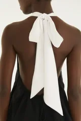 Top negro con escote halter, diseño sin mangas, confeccionado en mezcla de viscosa y poliéster.