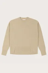 Buzo de punto color beige, con cuello redondo, mangas largas y diseño con aberturas laterales en el ruedo.