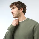 Buzo de cuello redondo verde con textura tipo nido de abeja, mangas largas y puños elastizados.