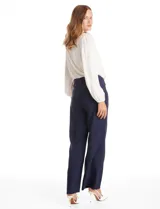Pantalón sastrero de tiro alto y pierna ancha, con cierre frontal y gancho interno. Presenta bolsillos laterales de ojal y un diseño minimalista con caída fluida.