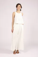 Blusa blanca de broderie con cuello redondo y sin mangas.