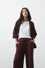 Campera con capucha y cierre frontal, de silueta relajada, hombros caídos y bolsillos laterales. Presenta terminaciones elastizadas en puños y ruedo, con líneas de recorte frontales y cierre metálico con tirador circular.