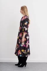 Vestido midi de viscosa con estampado floral multicolor sobre fondo negro. Presenta escote redondo con detalle de tablas, mangas tipo balloon y ajuste en la cintura mediante lazo lateral.