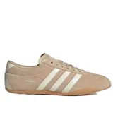 Championes Adidas Tokyo de mujer, confeccionados en gamuza suave de color beige con las icónicas tres tiras y detalles en blanco, y suela de caucho.
