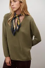 Sweater de tejido de punto color beige, con escote en V y mangas largas. Presenta un diseño básico y versátil de corte recto.