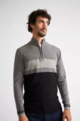 Sweater de tejido de punto con diseño color block en tonos gris, gris claro y negro. Presenta cuello levemente elevado con cierre frontal parcial, mangas largas con puños acanalados y logo bordado en el pecho.