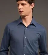Camisa de hombre, corte slim, color blanco, confeccionada en algodón y poliéster con tecnología Easy Care que ofrece elasticidad y secado rápido. Presenta cuello inglés y manga larga con puño abotonado.