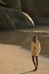 Short de tiro medio de lino 100%, color amarillo claro. Presenta cintura elástica, cierre frontal con botones y bolsillos laterales ocultos en costura y de plastrón en la espalda. El bajo tiene aberturas laterales.