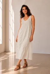 Vestido largo de lino azul marino, sin mangas, con escote en V y corte en la cintura. Presenta costuras pespunteadas a la vista y falda amplia con vuelo.