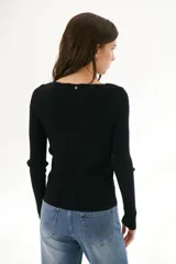 Buzo de morley color crema, con cuello bote y manga larga. Presenta un diseño de punto acanalado y un detalle de franja horizontal en el pecho.