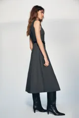 Vestido midi de cuello redondo y sin mangas, confeccionado en tejido jaspeado gris. Presenta un corte evasé y un cinturón ancho de cuero sintético negro con hebilla metálica. Incluye cierre posterior con cremallera oculta.