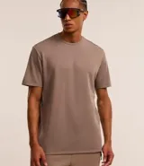 Remera deportiva de corte comfort, color marrón, con cuello redondo y manga corta. Confeccionada en tejido tech fleece con tecnología dry para mayor transpirabilidad.