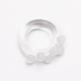 Anillo artesanal de vidrio transparente con diseño irregular y apliques esféricos de color blanco.