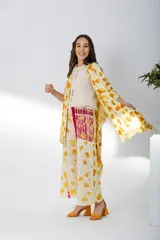 Pantalón de pierna ancha con estampado de hojas en tonos amarillos y marrones, cintura elastizada y bolsillos laterales.