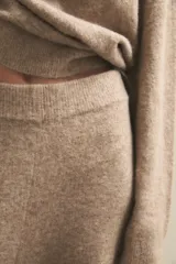 Pantalón de punto de tiro alto y corte recto, con cintura elástica. Presenta una textura suave y diseño holgado.