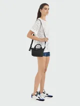 Bolso crossbody modelo Le Pliage Xtra XS de Longchamp, confeccionado en cuero negro. Presenta un diseño compacto con doble asa superior y correa ajustable y extraíble para llevar al hombro o cruzado. Incluye cierre de solapa con botón a presión y cierre principal con cremallera.