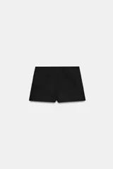 Falda pantalón de tiro medio color negro, con detalle de abertura en el delantero y cierre lateral con cremallera oculta.