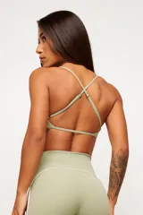 Conjunto deportivo de dos piezas en color verde pistacho, compuesto por un top de tirantes finos con escote recto y una calza larga de tiro alto con detalles de líneas en contraste.