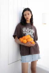 Remera blanca oversize de algodón con estampado de frutas y texto en el frente, pespuntes a contratono y tajos laterales.