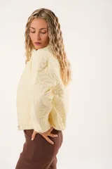 Campera color manteca con diseño acolchado de flores, cuello alto, cierre frontal con cremallera y bolsillos laterales.