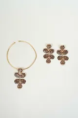 Set de collar rígido dorado con dije colgante y caravanas con forma de flor de tres pétalos con estampado animal print.