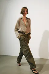 Jeans de tiro bajo y diseño barrel leg de la colección Zara Woman, en color verde militar con estampado floral en contraste, trabillas para cinturón y costuras decorativas frontales.