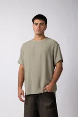 Remera de manga corta con cuello redondo, confeccionada en tejido de lino con textura entramada y corte holgado.