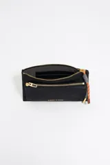 Cartera negra de estructura blanda con cierre de cremallera y tirador de cordón. Presenta logo metálico dorado "BIMBA Y LOLA" en el frente, acabados metálicos dorados y tarjetero interior.