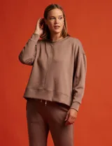 Buzo blanco de tejido elastizado, con pespunte central en la parte delantera y tajos laterales.