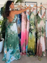Vestido largo verde con diseño estampado tipo tie-dye y detalles dorados, de corte fluido, un solo hombro y diseño amplio.