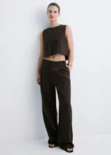 Pantalón de corte recto y tiro medio color marrón oscuro, confeccionado en lyocell, con detalle de pinzas delanteras, trabillas para cinto, bolsillos laterales y bolsillos de ribete en la parte posterior. Cierre frontal con botón y cremallera.