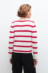 Chaqueta tejida con rayas horizontales rojas y blancas, cuello redondo y botones dorados.