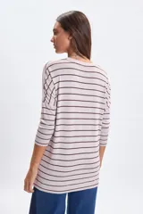 Remera de manga larga confeccionada en lanilla con diseño de rayas horizontales. Presenta cuello redondo y un corte holgado con caída fluida.
