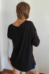 Remerón de corte oversize y diseño tricolor, con paneles en negro, beige y blanco. Presenta mangas tres cuartos y un calce holgado y fluido.