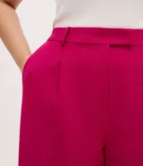 Pantalón de sastrería modelo pantalona, color fucsia, con corte amplio y recto. Presenta cintura con botón, elástico en la parte trasera para mayor ajuste y bolsillos laterales tipo cuchillo.