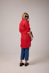 Campera roja capitoneada de nylon con forro de algodón, ruedo curvo, largo midi, cinta para atar a la cintura y bolsillos delanteros.