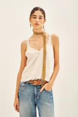 Top negro de viscosa con breteles finos y escote en V con puntilla. Presenta apliques de tachas termo adhesivas en el frente.