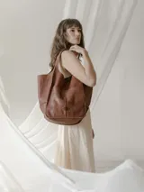 Bolso shopper de piel vacuna lavada, color beige, con cierre de botón y bolsillo frontal.