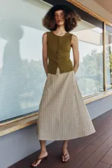 Falda midi de tiro alto con estampado de cuadros, diseño cruzado y detalle de botón en la cintura.