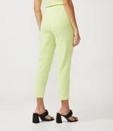 Pantalón zanahoria color verde lima, de crepé con cintura alta, detalle de aro en la cintura y pliegues delanteros.